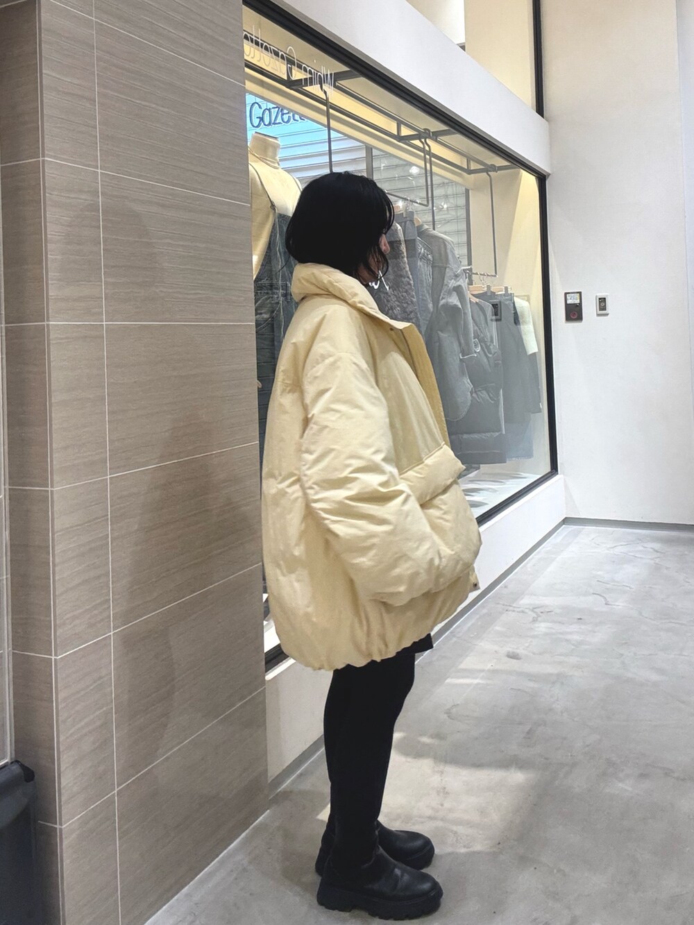 イエロー系のダウンジャケット/コート、ブラウン系のその他パンツ、ブラック系のブーツを着用したレディースの秋コーディネートの5枚目の写真