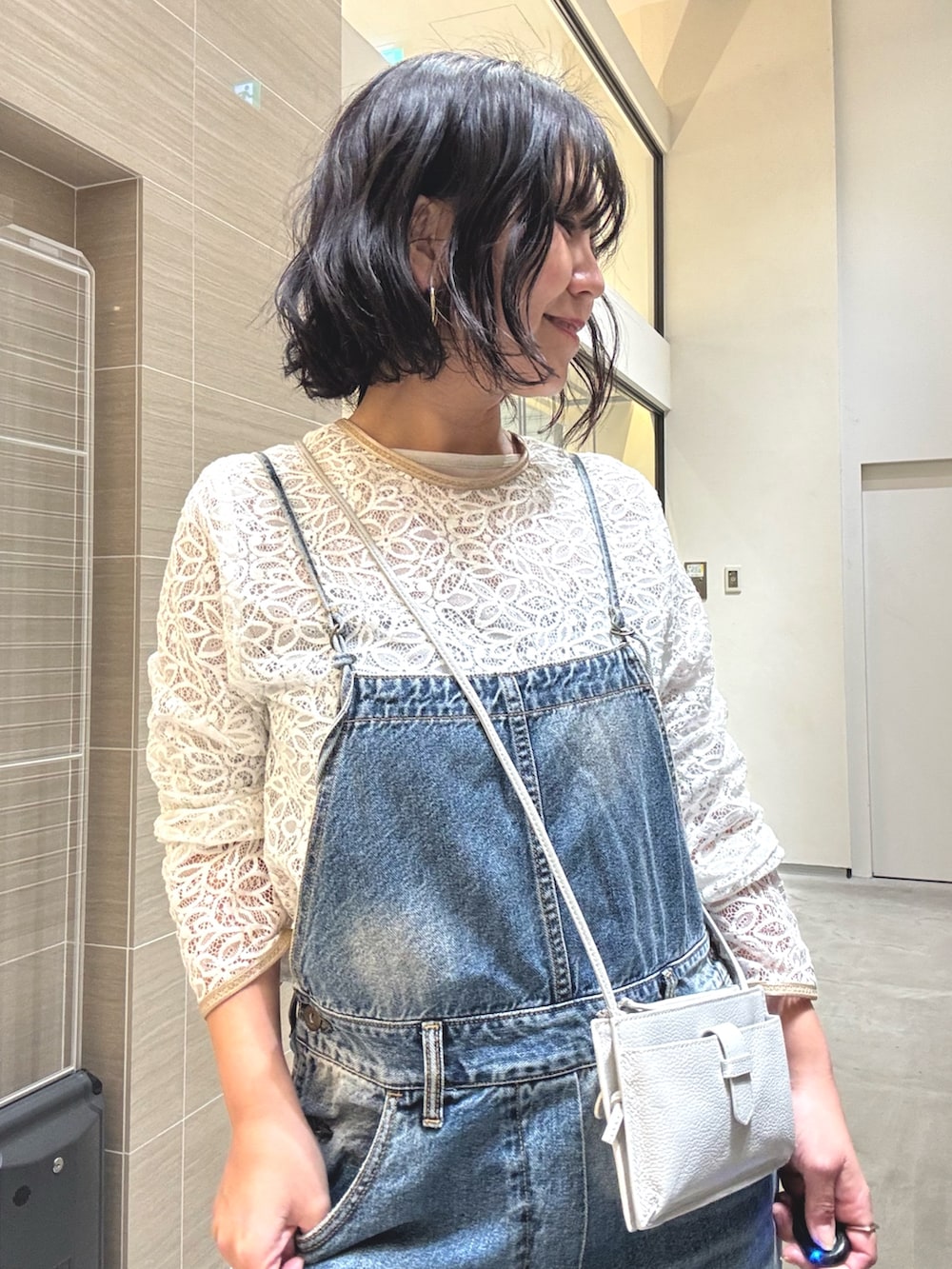 ブルー系のつなぎ/オールインワン、ホワイト系のシャツ/ブラウス、グレー系のショルダーバッグを着用したレディースの冬コーディネートの6枚目の写真