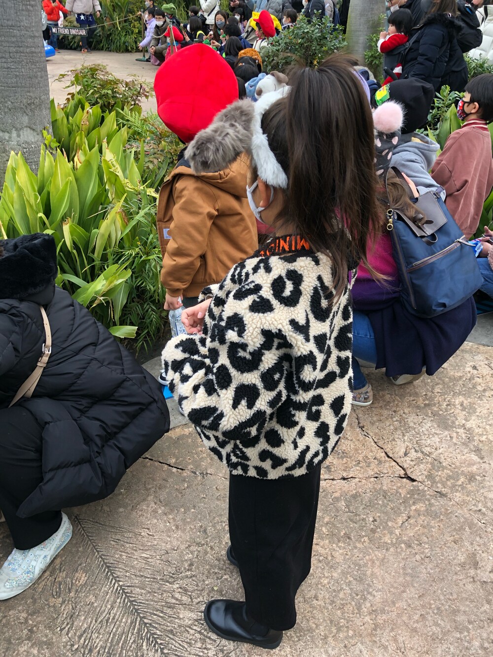 ブラウン系のジャケット/アウター、グリーン系のオールインワン・サロペット、ブラック系のスニーカーを着用したキッズの冬コーディネートの2枚目の写真