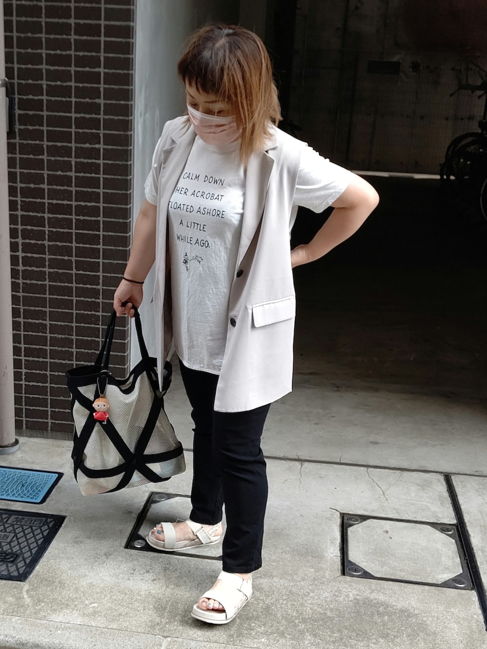 グレー系のベスト、ブラック系のその他パンツ、ホワイト系のサンダルを着用したレディースの夏コーディネートの2枚目の写真