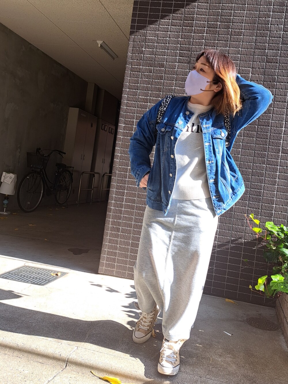 ブルー系のデニムジャケット、ホワイト系のニット/セーター、グレー系のスカートを着用したレディースの冬コーディネートの2枚目の写真