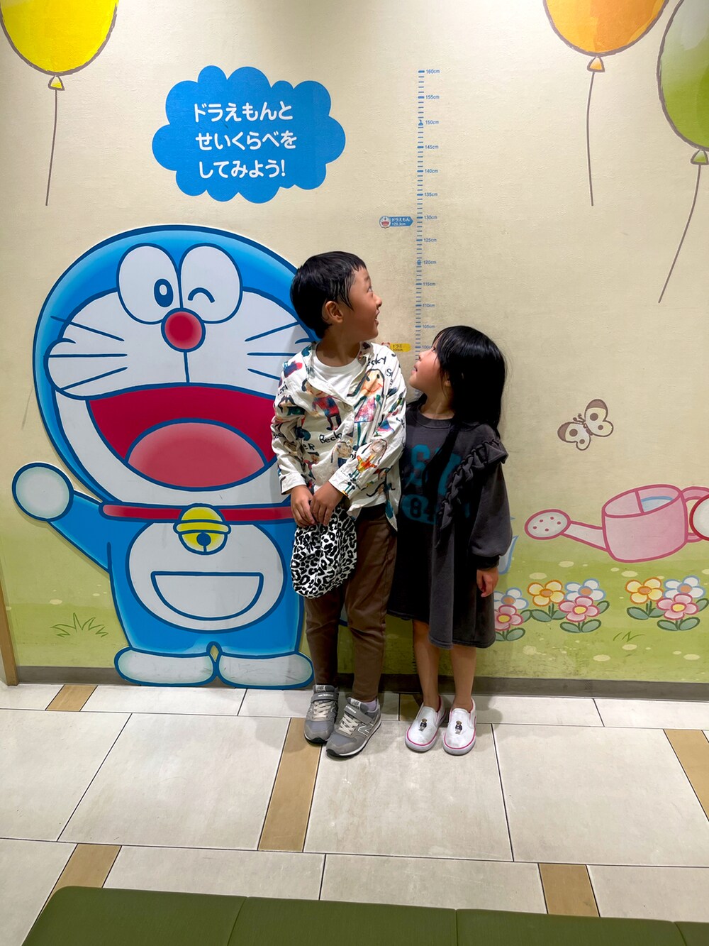 ブルー系のエコバッグ/サブバッグ、ホワイト系のシャツ/ブラウス、ブラウン系のチノパンツを着用したレディースの冬コーディネートの2枚目の写真