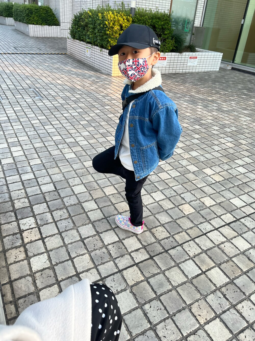 ブルー系のデニムジャケット、ブラック系のパンツ、ピンク系のスニーカーを着用したレディースの春コーディネートの2枚目の写真