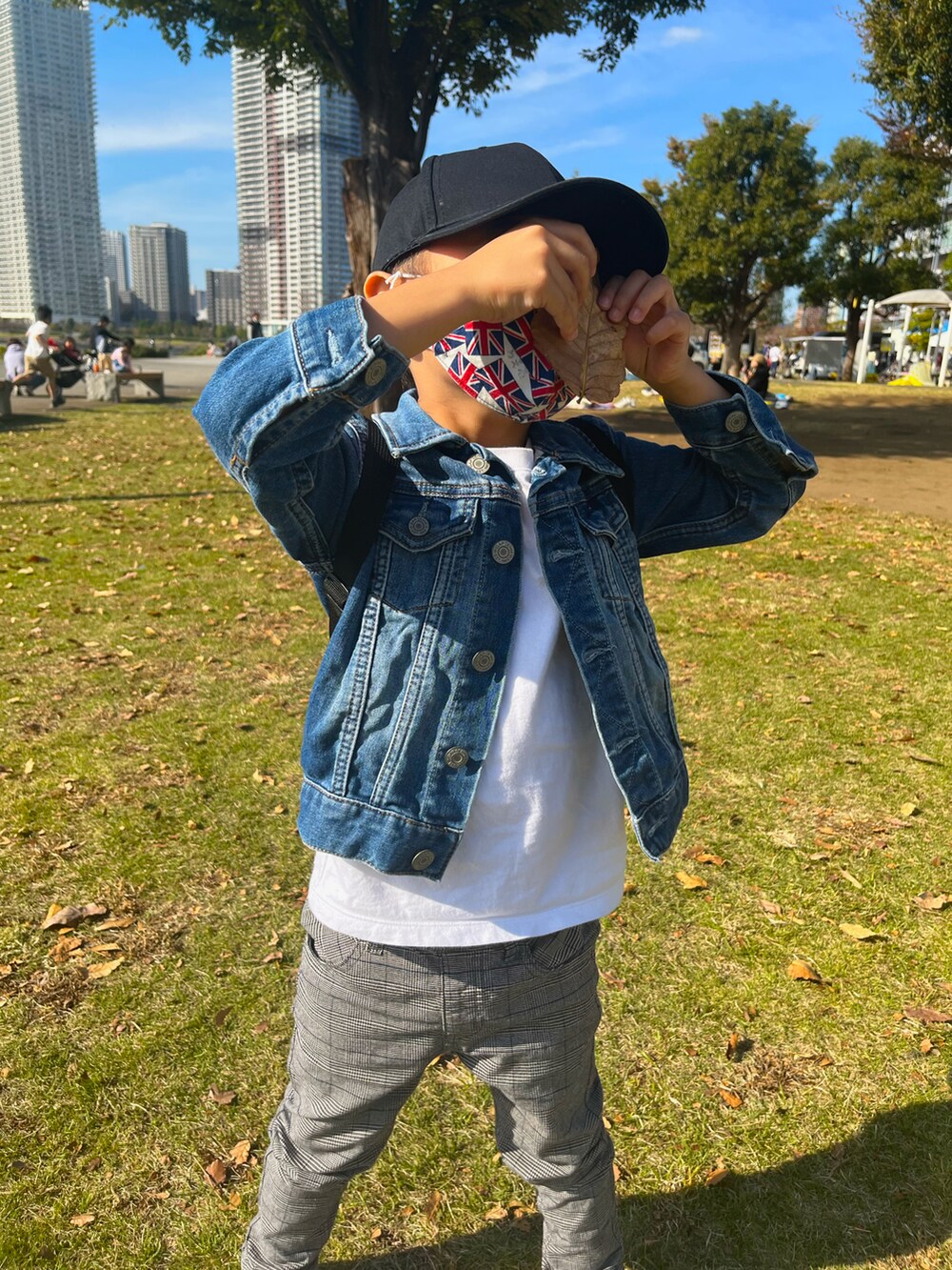 ブルー系のデニムジャケット、グレー系のパンツ、ホワイト系のスニーカーを着用したレディースの春コーディネートの3枚目の写真