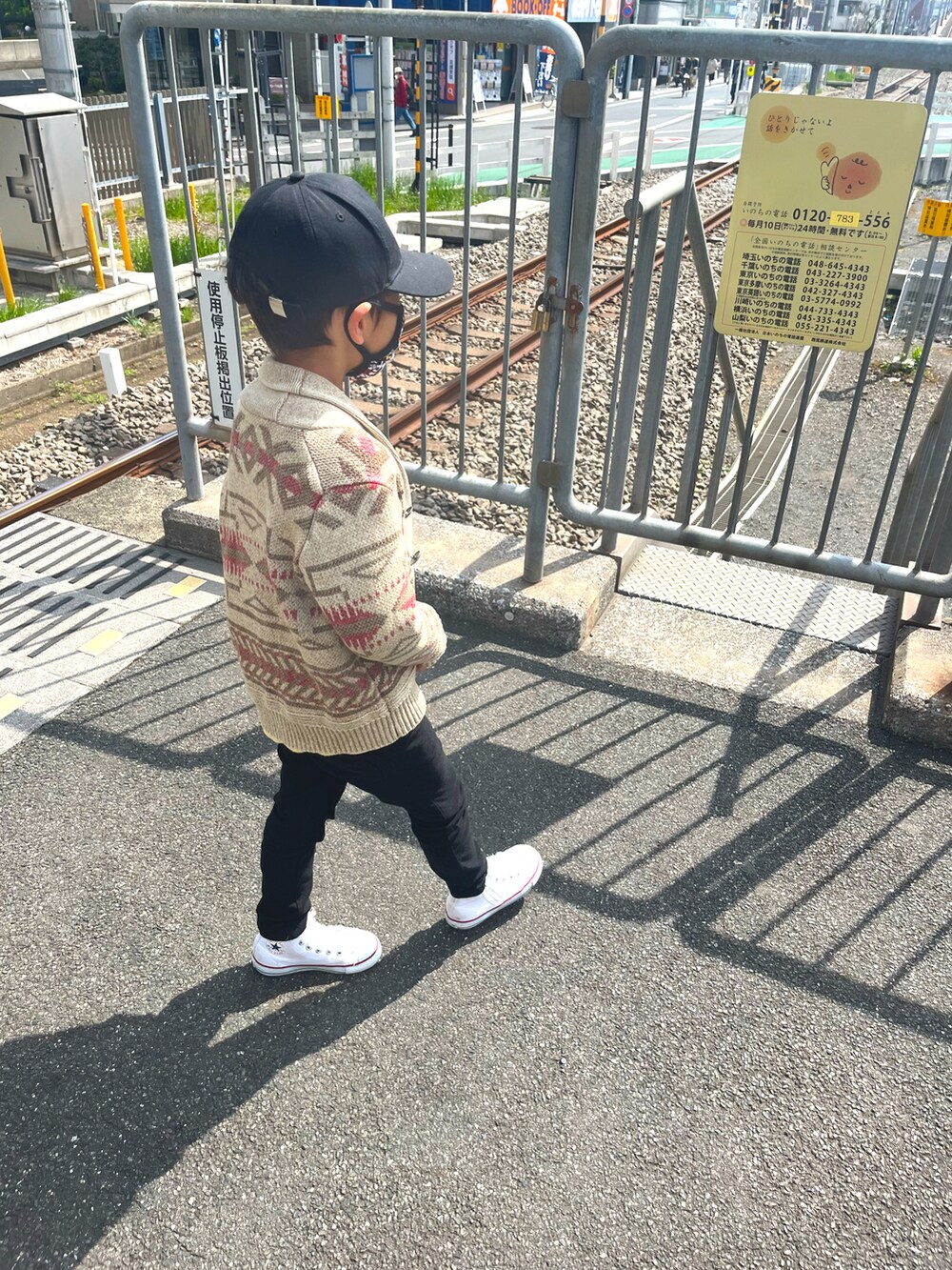 ブラウン系のニット/セーター、イエロー系のTシャツ/カットソー、ブラック系のパンツを着用したレディースの春コーディネートの3枚目の写真