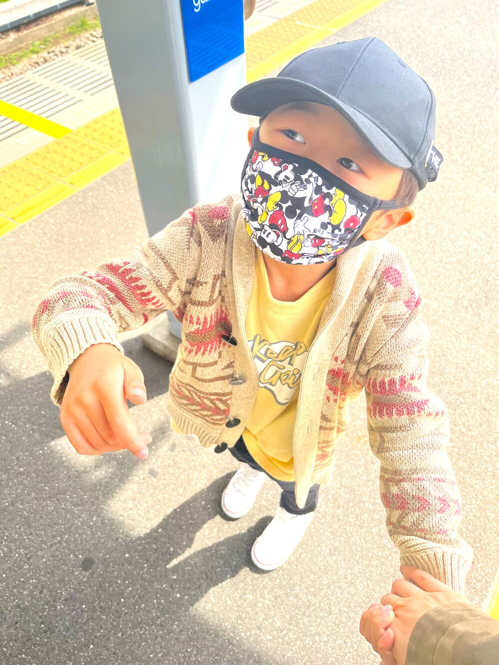 ブラウン系のニット/セーター、イエロー系のTシャツ/カットソー、ブラック系のパンツを着用したレディースの春コーディネートの4枚目の写真