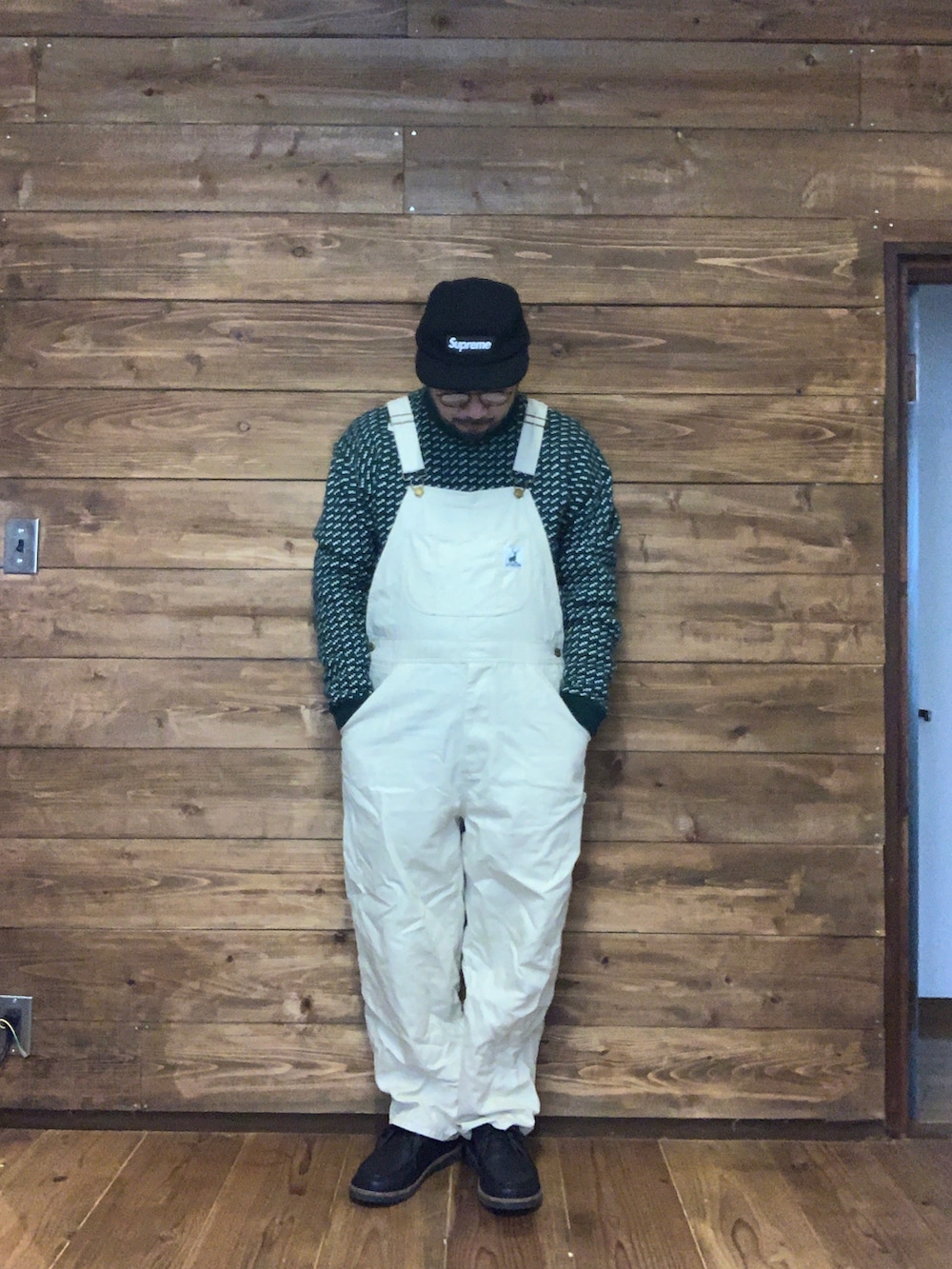 グリーン系のサロペット/オーバーオール、ブラック系のブルゾン、グリーン系のニット/セーターを着用したメンズの冬コーディネートの2枚目の写真