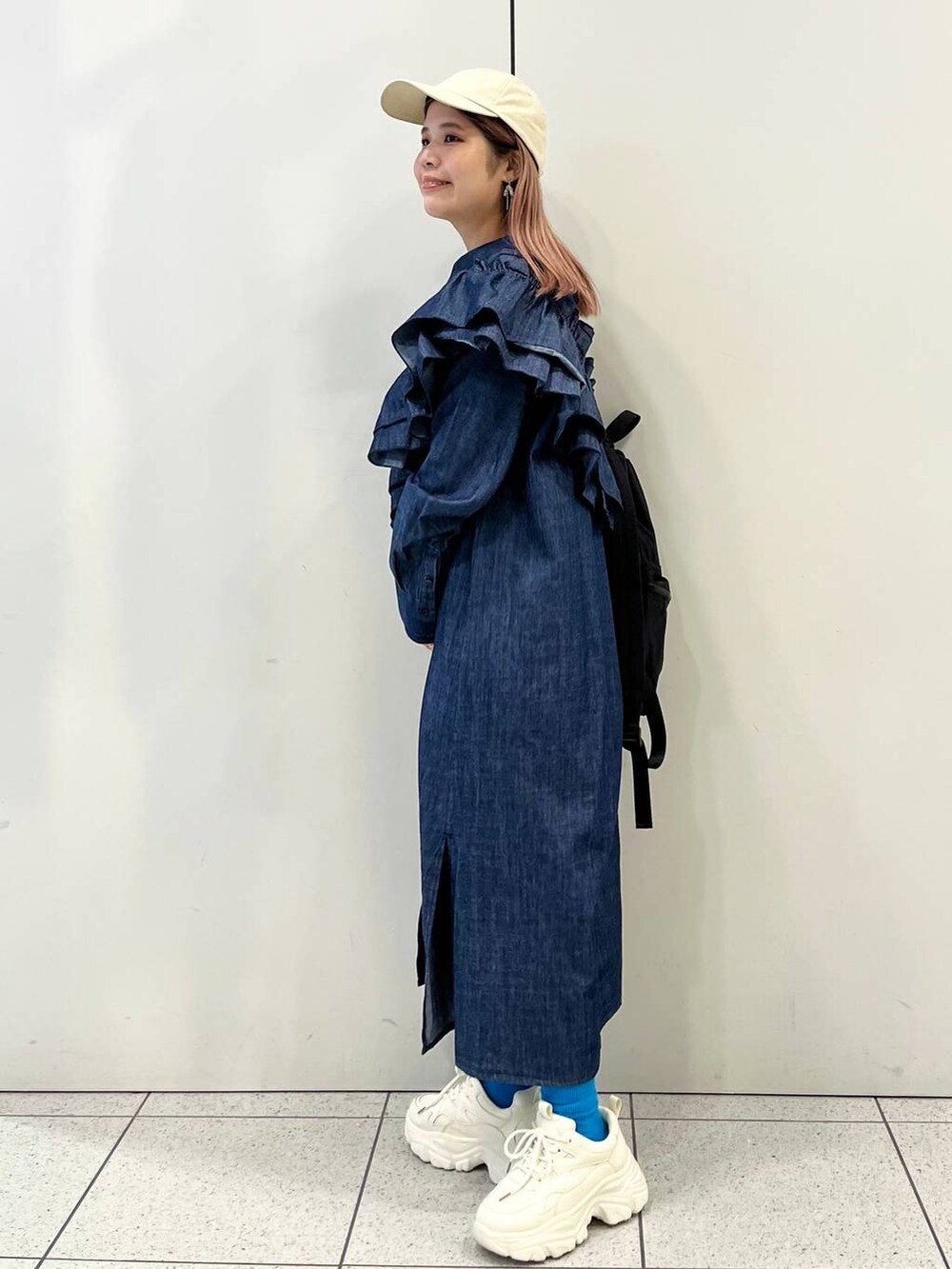 ホワイト系のスニーカー、ブラック系のバックパック/リュック、ブルー系のワンピースを着用したレディースの冬コーディネートの3枚目の写真