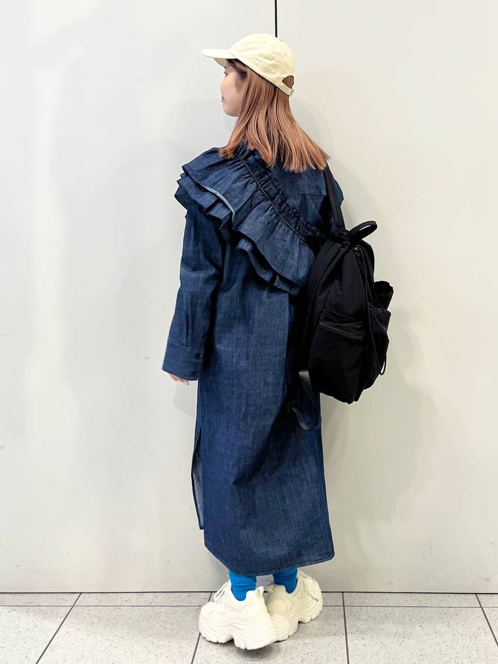 ホワイト系のスニーカー、ブラック系のバックパック/リュック、ブルー系のワンピースを着用したレディースの冬コーディネートの7枚目の写真