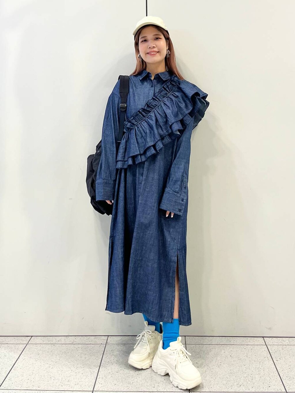 ホワイト系のスニーカー、ブラック系のバックパック/リュック、ブルー系のワンピースを着用したレディースの冬コーディネートの5枚目の写真