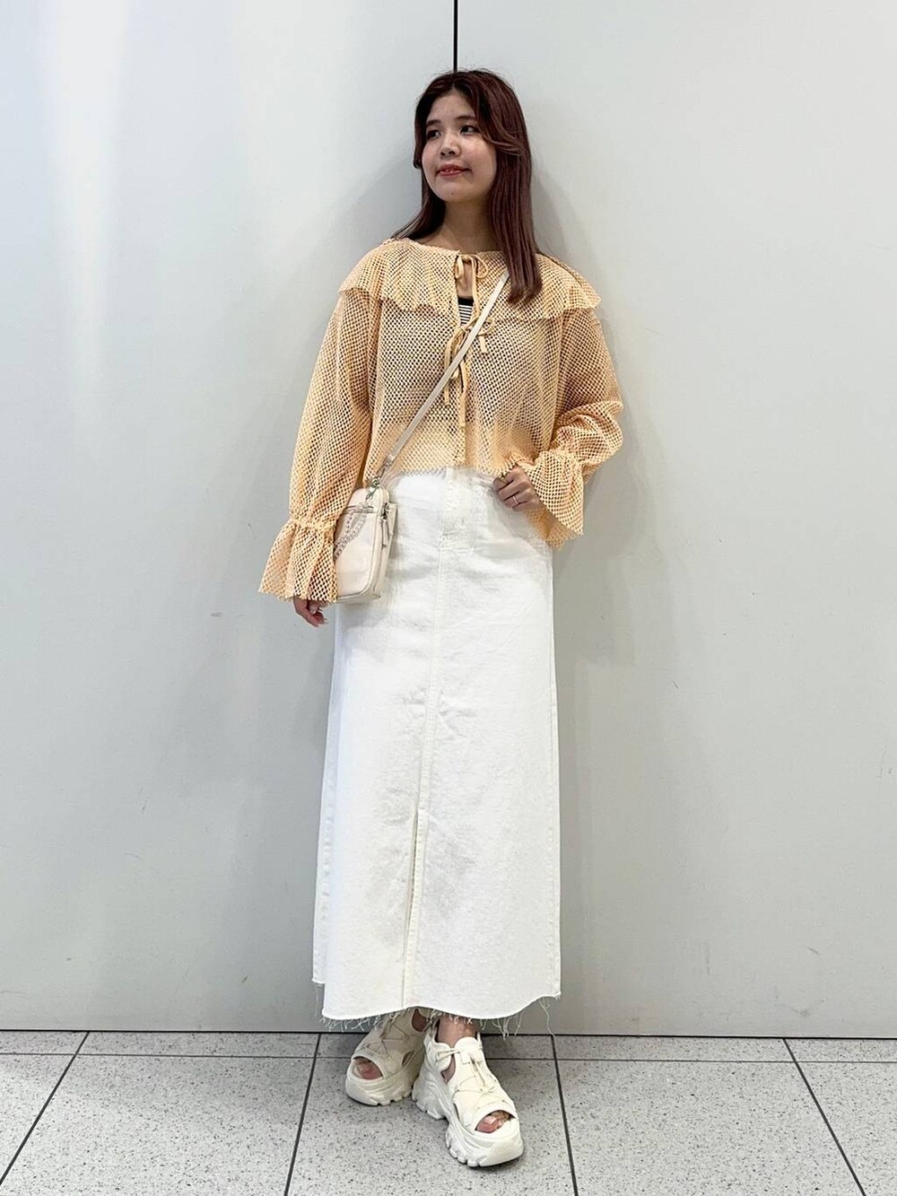 ベージュ系のショルダーバッグ、ホワイト系のサンダル、ブラック系のタンクトップを着用したレディースの春コーディネートの2枚目の写真