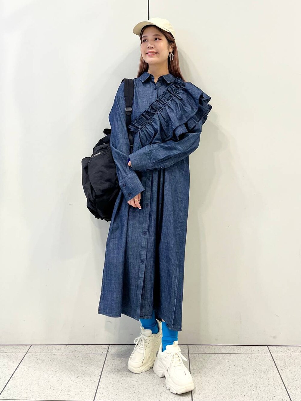 ホワイト系のスニーカー、ブラック系のバックパック/リュック、ブルー系のワンピースを着用したレディースの冬コーディネートの6枚目の写真