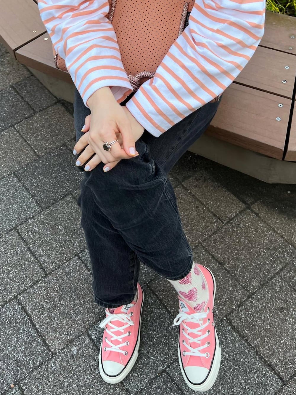 ブラック系のデニムパンツ、ピンク系のTシャツ/カットソー、ピンク系のボストンバッグを着用したレディースの春コーディネートの3枚目の写真