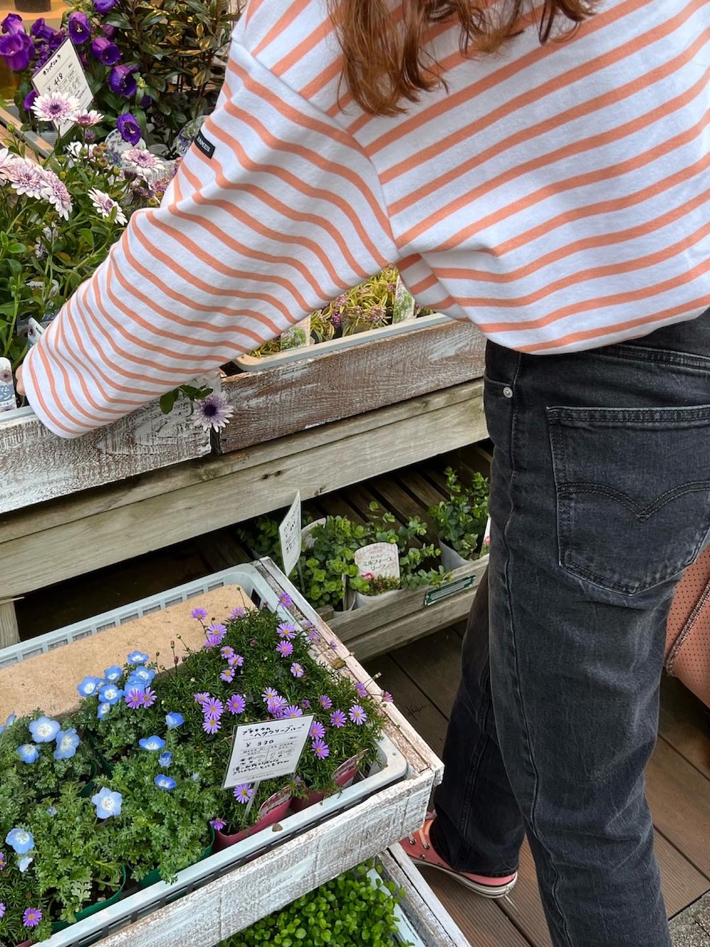 ブラック系のデニムパンツ、ピンク系のTシャツ/カットソー、ピンク系のボストンバッグを着用したレディースの春コーディネートの2枚目の写真