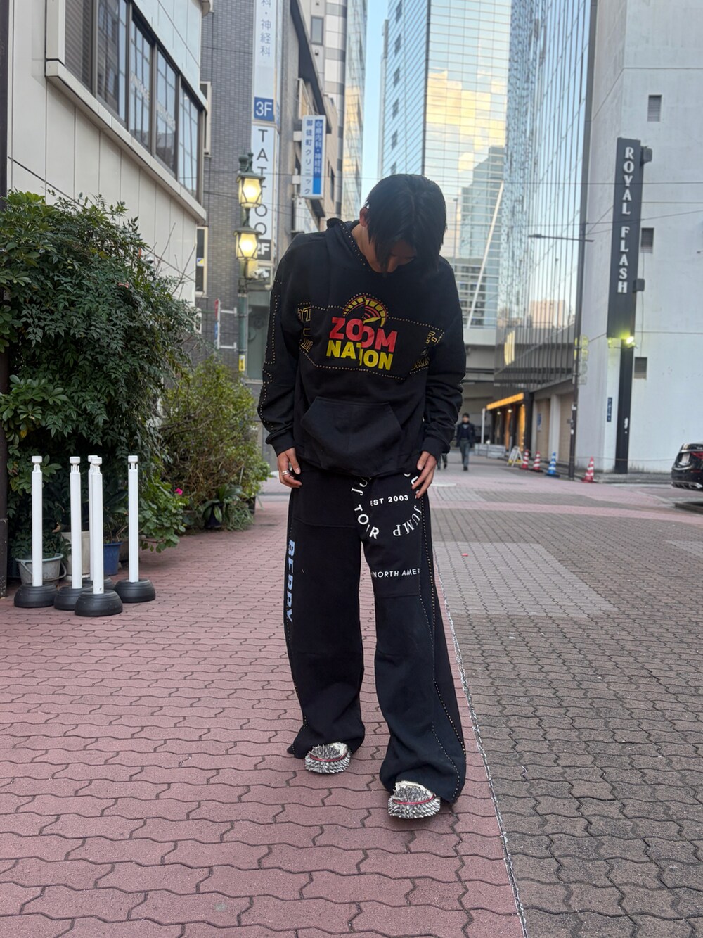 ブラック系のパンツ、ブラック系のトップス、ホワイト系のシューズを着用したメンズの冬コーディネートの5枚目の写真