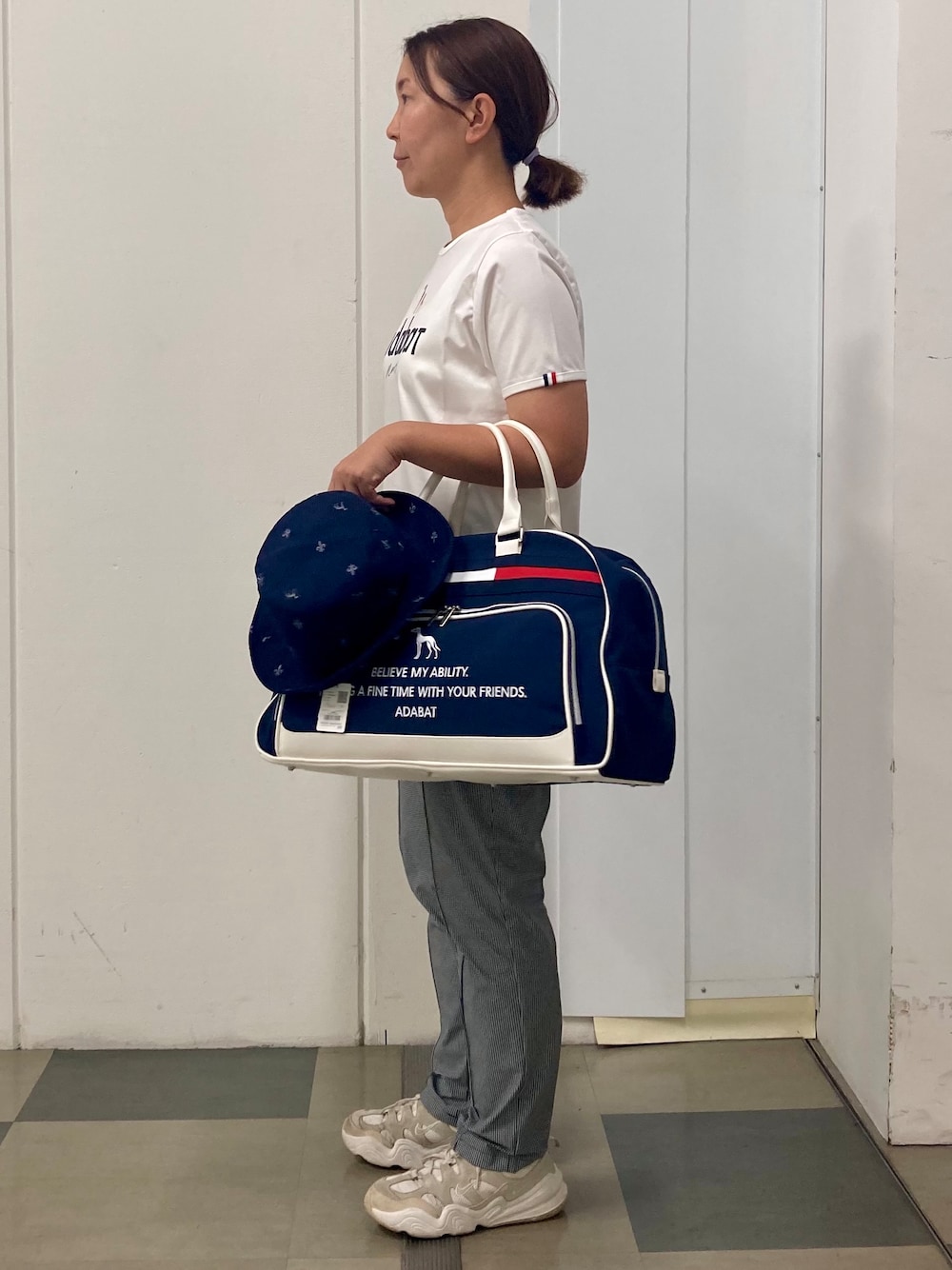 ホワイト系のTシャツ/カットソー、ブラック系のその他パンツ、ブルー系のボストンバッグを着用したレディースの夏コーディネートの2枚目の写真