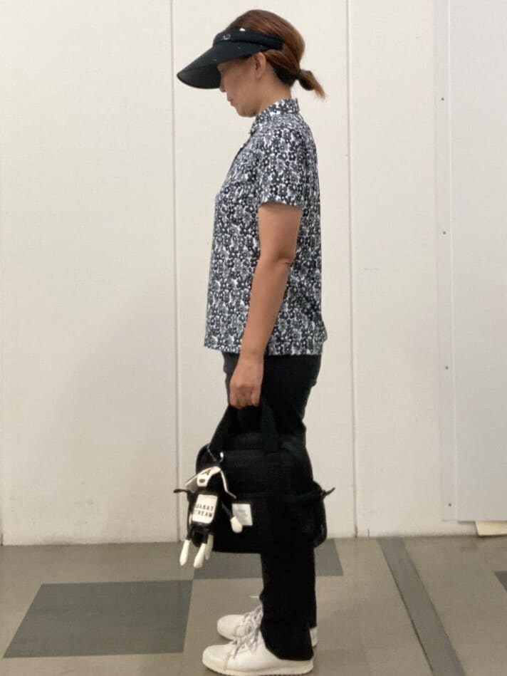 ブラック系のポロシャツ、ブラック系のその他パンツ、ブラック系のハンドバッグを着用したレディースの夏コーディネートの2枚目の写真