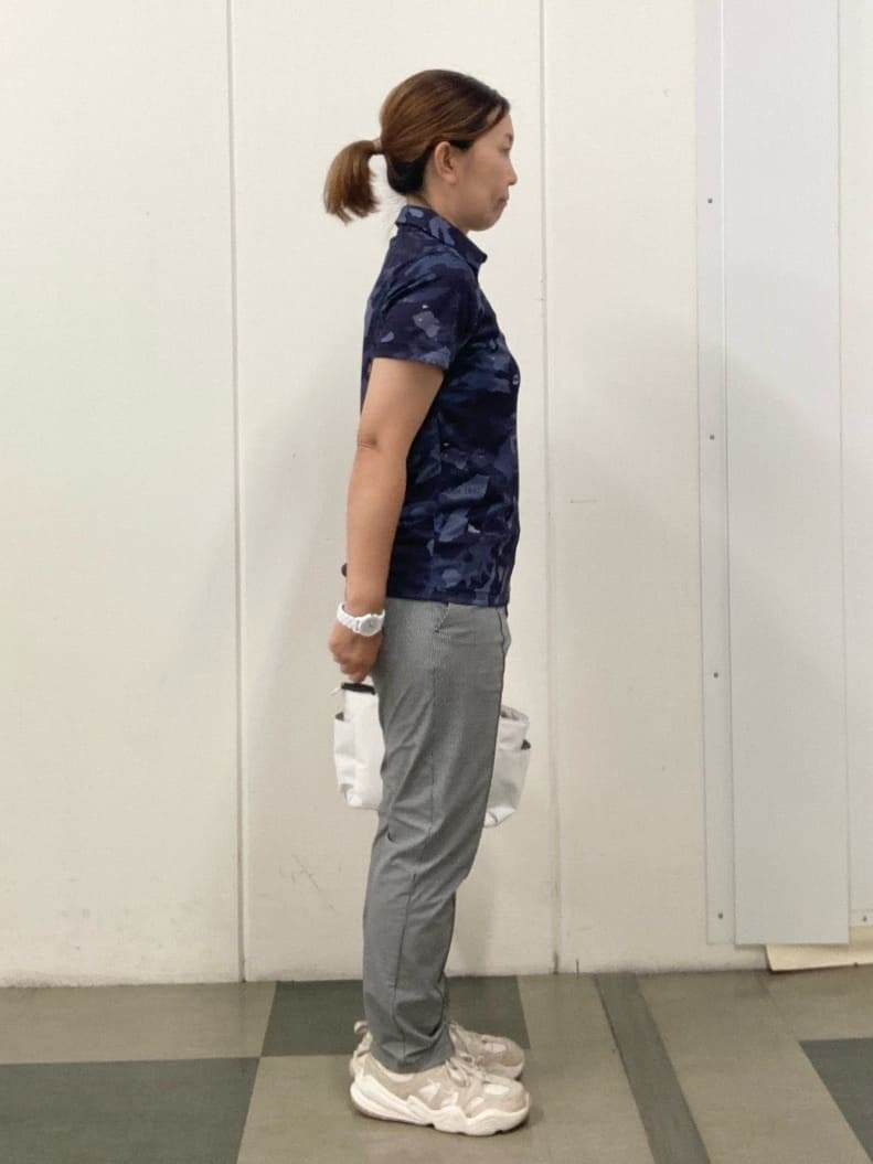 ブルー系のポロシャツ、ホワイト系のハンドバッグ、レッド系のサンバイザーを着用したレディースの夏コーディネートの4枚目の写真
