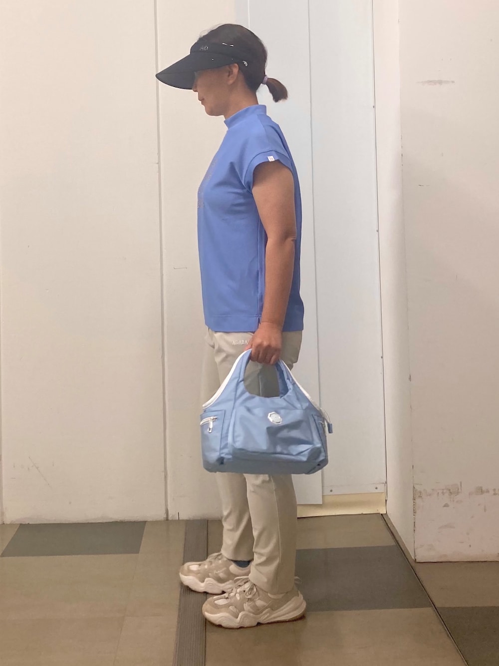 ブルー系のTシャツ/カットソー、ベージュ系のその他パンツ、ブルー系のショルダーバッグを着用したレディースの春コーディネートの2枚目の写真
