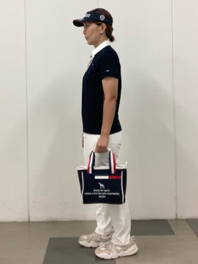 ブルー系のポロシャツ、ホワイト系のその他パンツ、ブルー系のトートバッグを着用したレディースの夏コーディネートの2枚目の写真