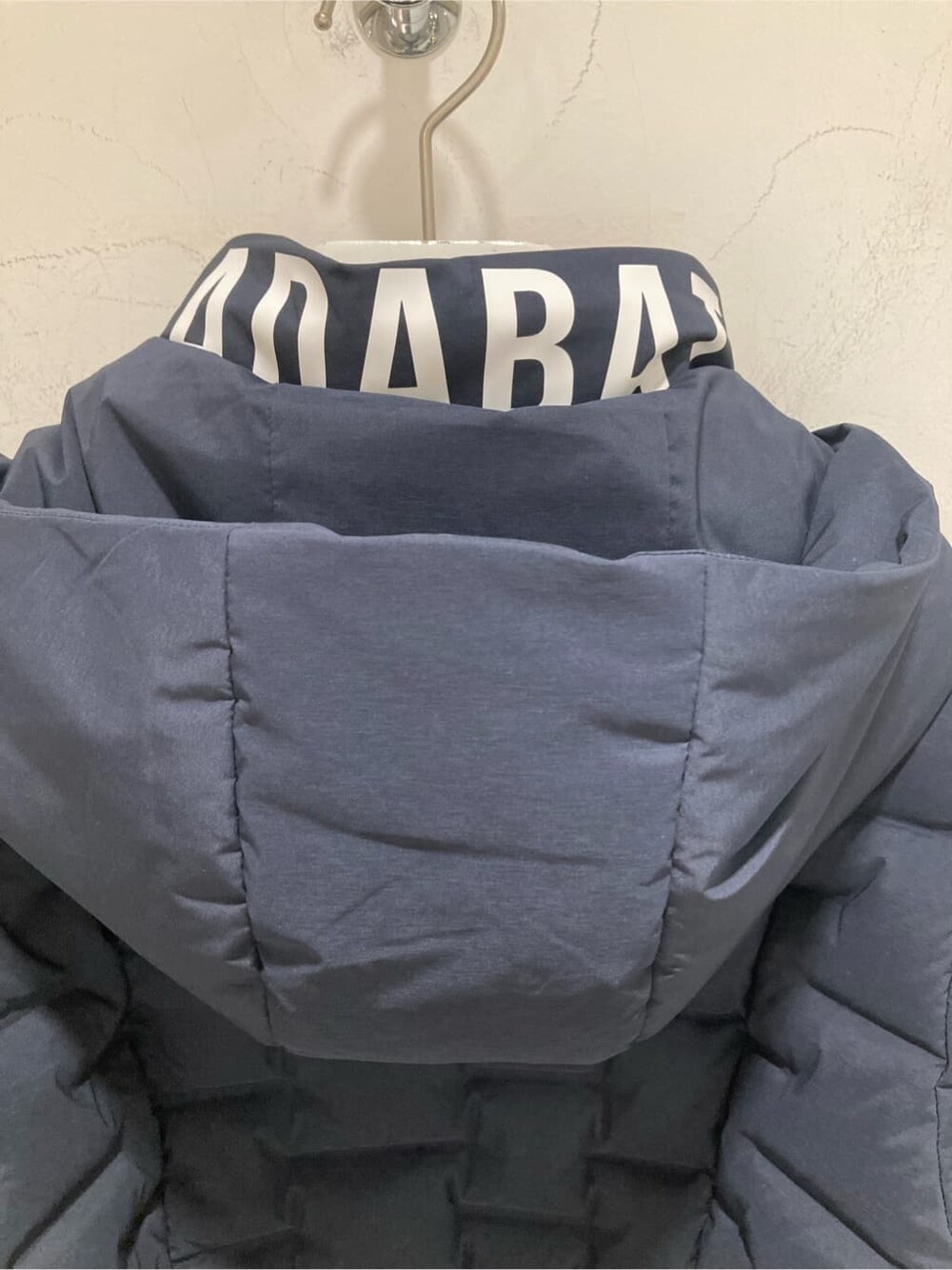 ブルー系のダウンジャケット/コート、グリーン系のニット/セーター、グレー系のその他パンツを着用したレディースの秋コーディネートの5枚目の写真
