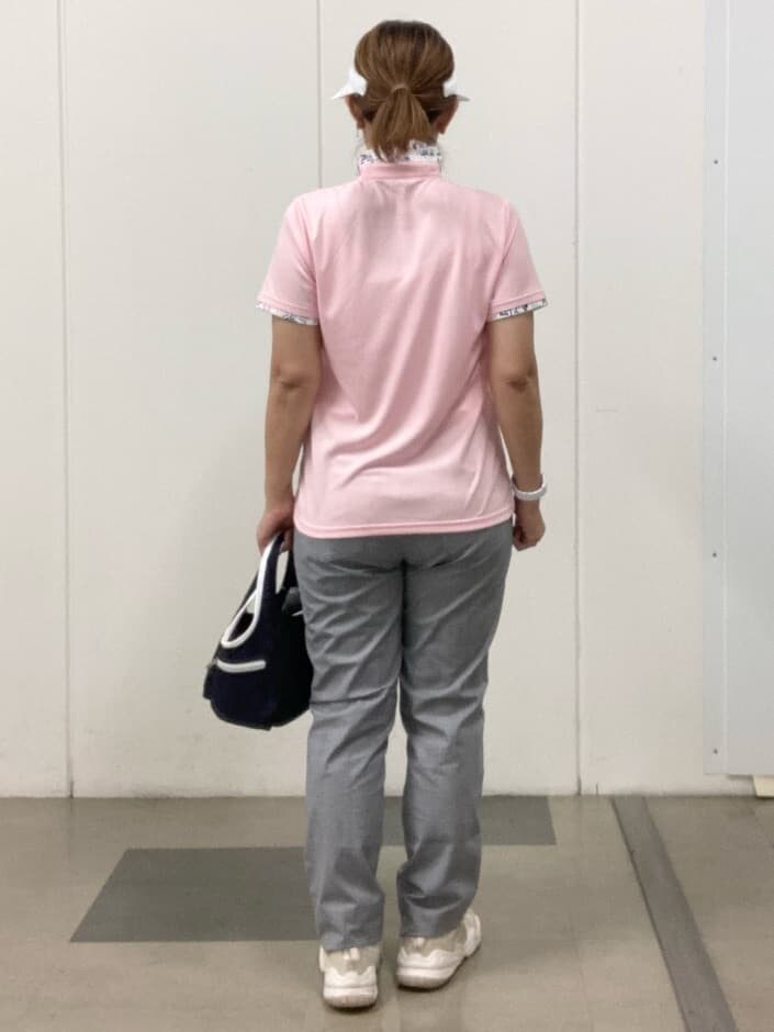 ピンク系のポロシャツ、ホワイト系のその他パンツ、ブルー系のショルダーバッグを着用したレディースの春コーディネートの3枚目の写真