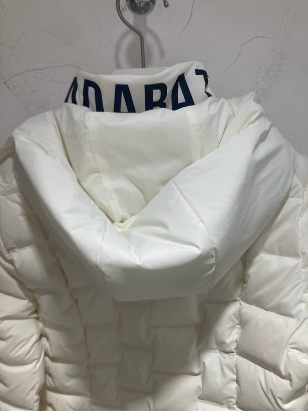グリーン系のニット/セーター、ホワイト系のダウンジャケット/コート、グレー系のその他パンツを着用したレディースの秋コーディネートの5枚目の写真