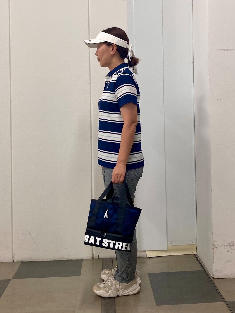ブラック系のその他パンツ、ブルー系のトートバッグ、ブルー系のポロシャツを着用したレディースの夏コーディネートの2枚目の写真