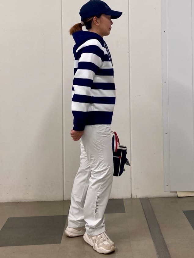 ブルー系のニット/セーター、ホワイト系のその他パンツ、グレー系のトートバッグを着用したレディースの秋コーディネートの4枚目の写真