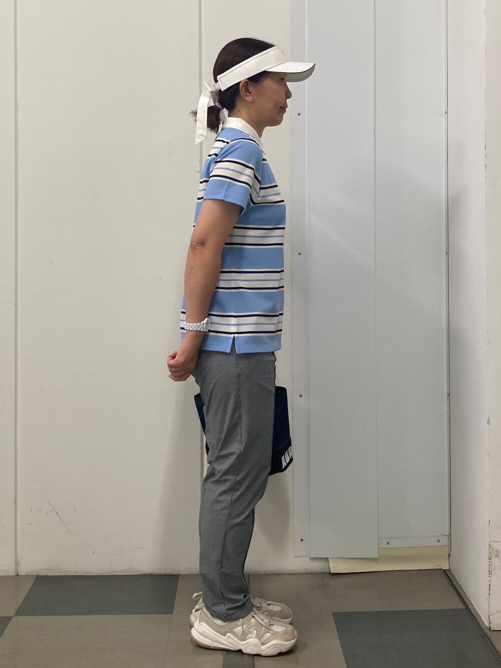 ブルー系のポロシャツ、ブラック系のその他パンツ、ブルー系のトートバッグを着用したレディースの夏コーディネートの2枚目の写真