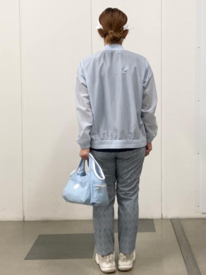 ブルー系のその他パンツ、ブルー系のショルダーバッグ、ホワイト系のサンバイザーを着用したレディースの春コーディネートの3枚目の写真