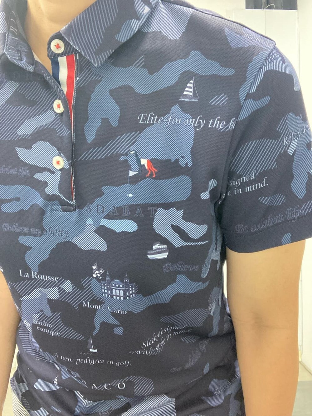 ブルー系のポロシャツ、ホワイト系のハンドバッグ、レッド系のサンバイザーを着用したレディースの夏コーディネートの5枚目の写真