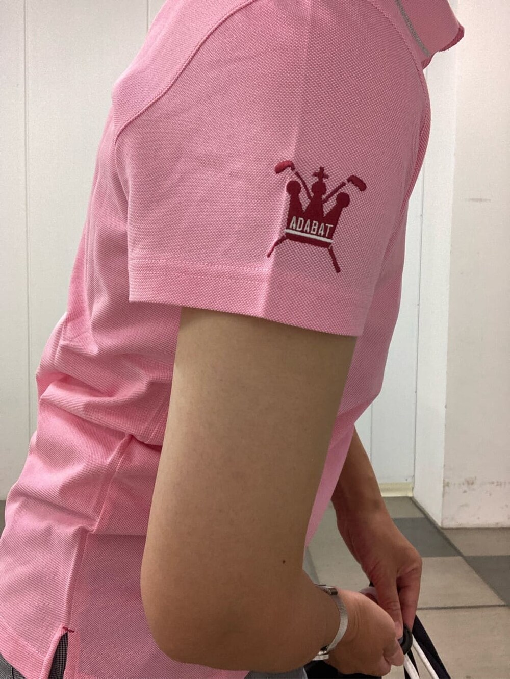 ホワイト系のその他パンツ、ピンク系のポロシャツ、ブルー系のサンバイザーを着用したレディースの夏コーディネートの6枚目の写真