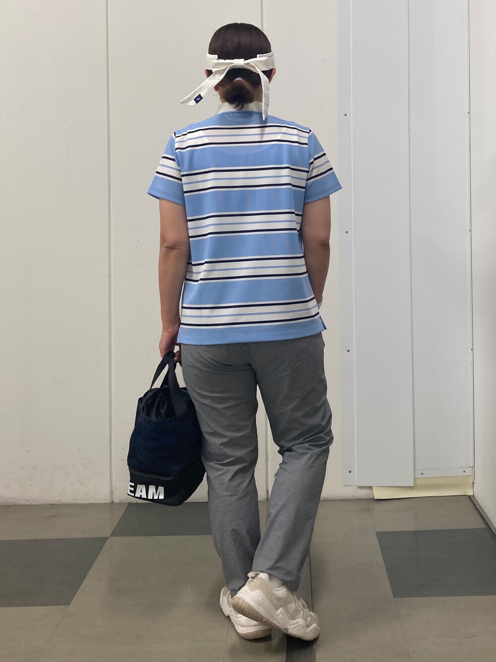 ブルー系のポロシャツ、ブラック系のその他パンツ、ブルー系のトートバッグを着用したレディースの夏コーディネートの4枚目の写真