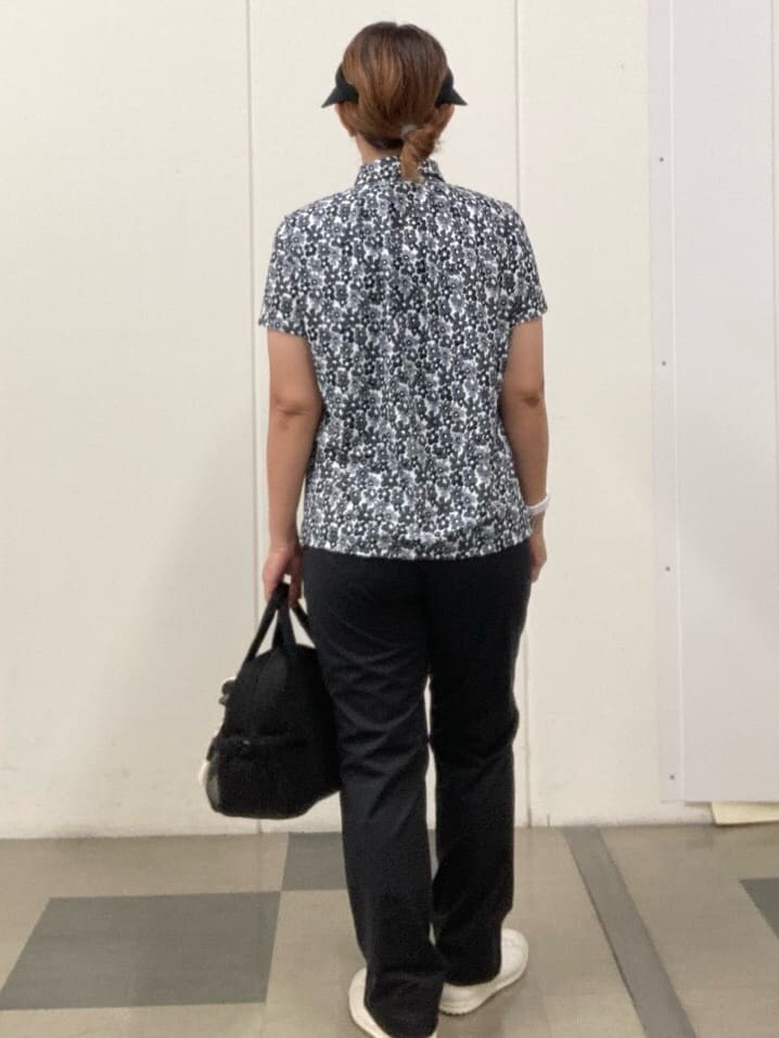 ブラック系のポロシャツ、ブラック系のその他パンツ、ブラック系のハンドバッグを着用したレディースの夏コーディネートの3枚目の写真