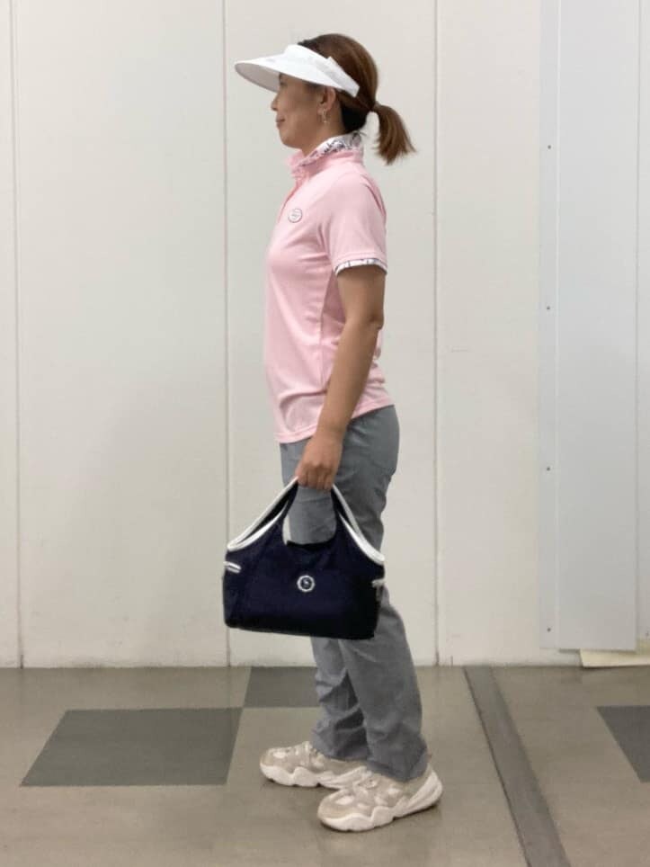 ピンク系のポロシャツ、ホワイト系のその他パンツ、ブルー系のショルダーバッグを着用したレディースの春コーディネートの2枚目の写真