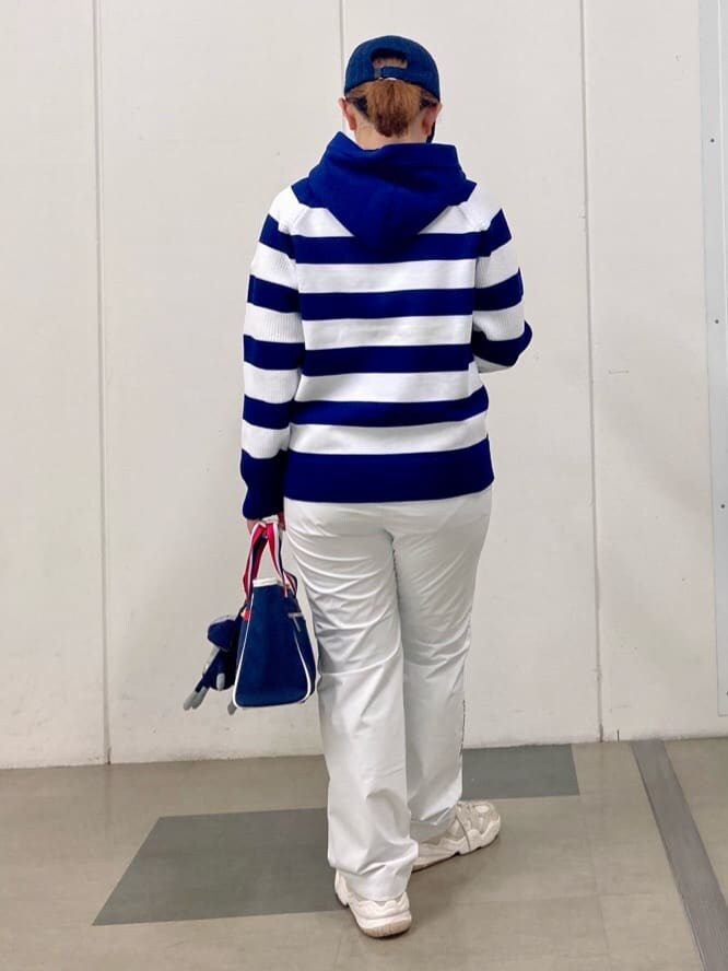 ブルー系のニット/セーター、ホワイト系のその他パンツ、グレー系のトートバッグを着用したレディースの秋コーディネートの3枚目の写真
