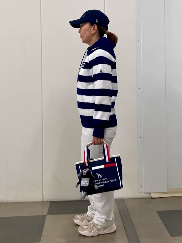 ブルー系のニット/セーター、ホワイト系のその他パンツ、グレー系のトートバッグを着用したレディースの秋コーディネートの2枚目の写真
