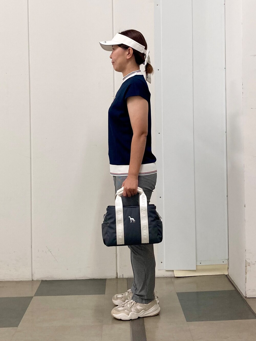 ブラック系のその他パンツ、ブルー系のTシャツ/カットソー、ホワイト系のサンバイザーを着用したレディースの夏コーディネートの2枚目の写真