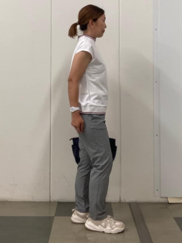 ブルー系のハンドバッグ、レッド系のキャップを着用したレディースの春コーディネートの3枚目の写真