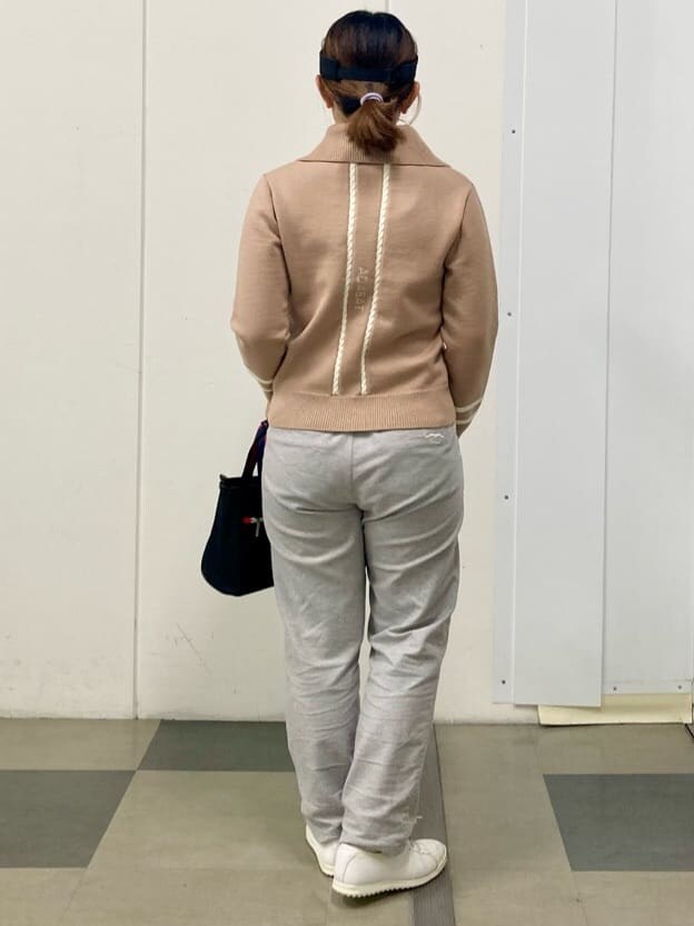 ベージュ系のニット/セーター、グレー系のその他パンツ、ブラック系のトートバッグを着用したレディースの冬コーディネートの2枚目の写真
