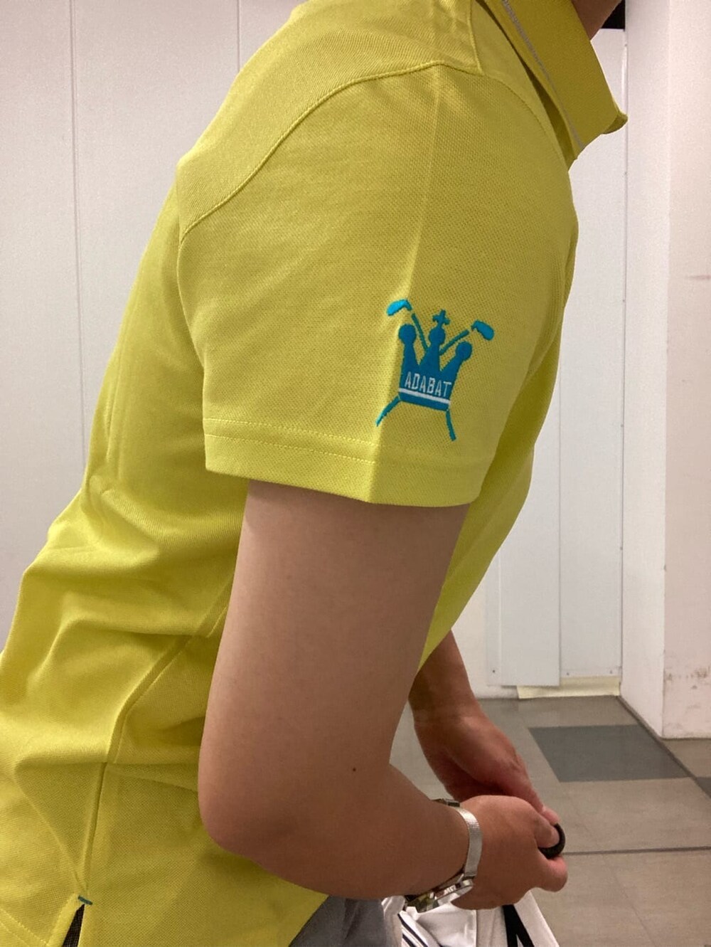 ホワイト系のその他パンツ、イエロー系のポロシャツ、ホワイト系のサンバイザーを着用したレディースの夏コーディネートの6枚目の写真