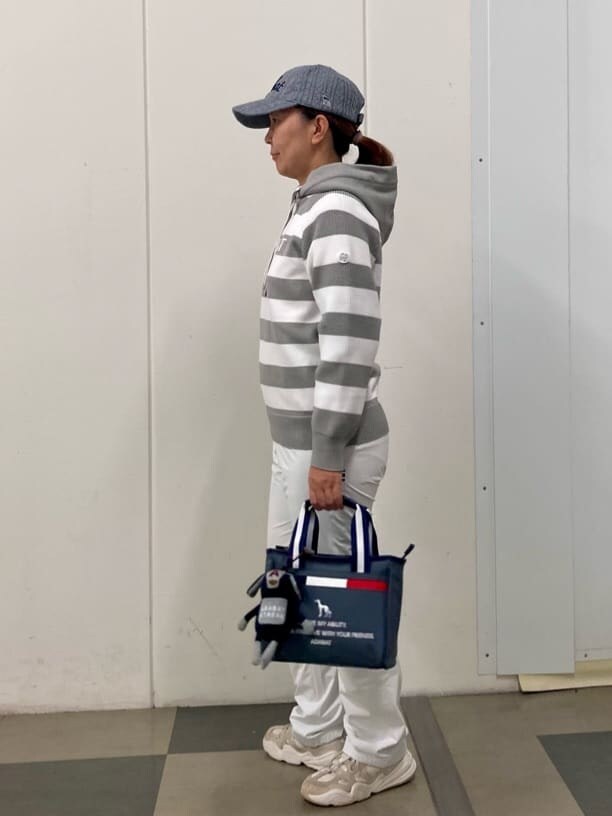 グレー系のニット/セーター、ホワイト系のその他パンツ、グレー系のトートバッグを着用したレディースの秋コーディネートの2枚目の写真