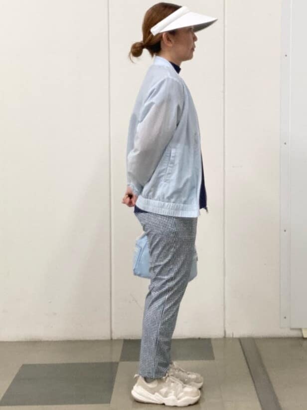 ブルー系のその他パンツ、ブルー系のショルダーバッグ、ホワイト系のサンバイザーを着用したレディースの春コーディネートの4枚目の写真