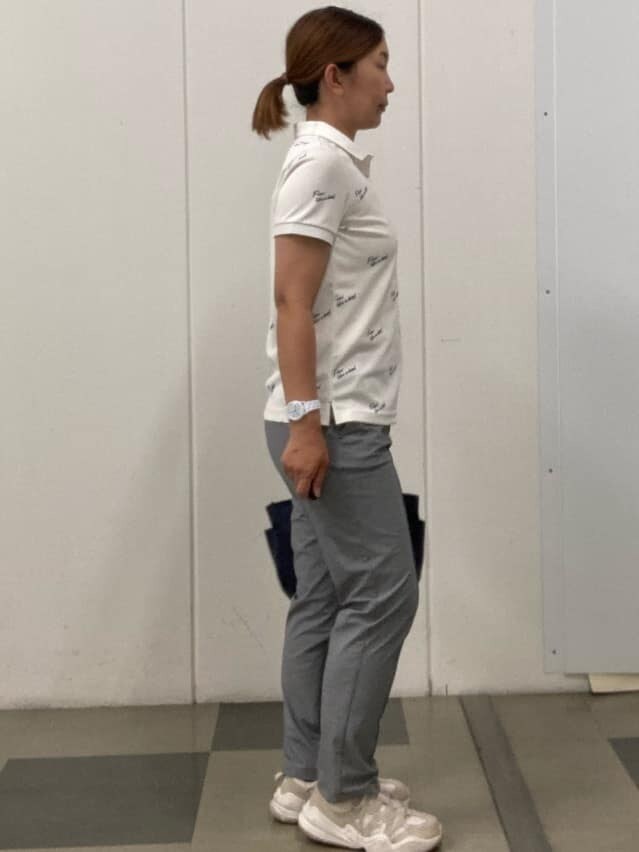 ホワイト系のポロシャツ、ブルー系のハンドバッグ、ブルー系のキャップを着用したレディースの春コーディネートの4枚目の写真