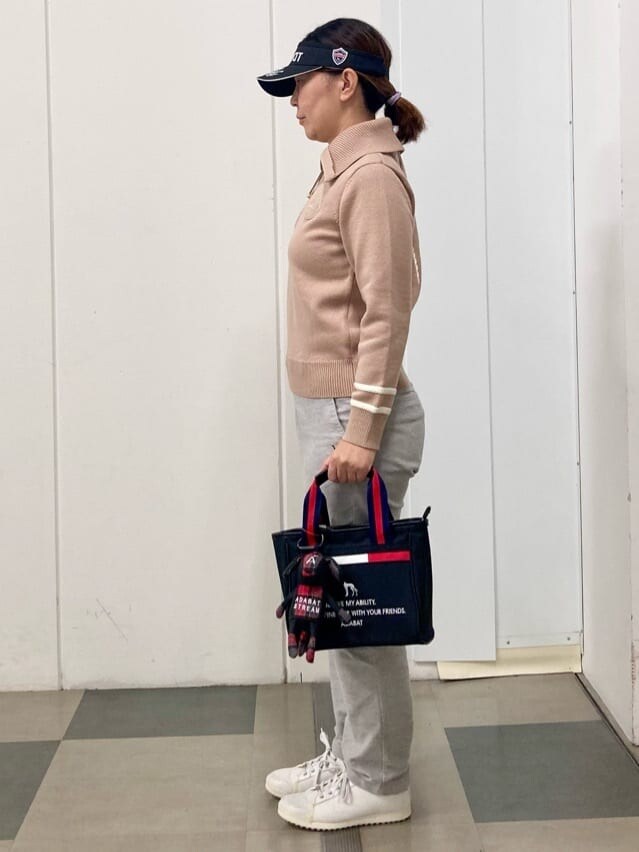 ベージュ系のニット/セーター、グレー系のその他パンツ、ブラック系のトートバッグを着用したレディースの冬コーディネートの4枚目の写真