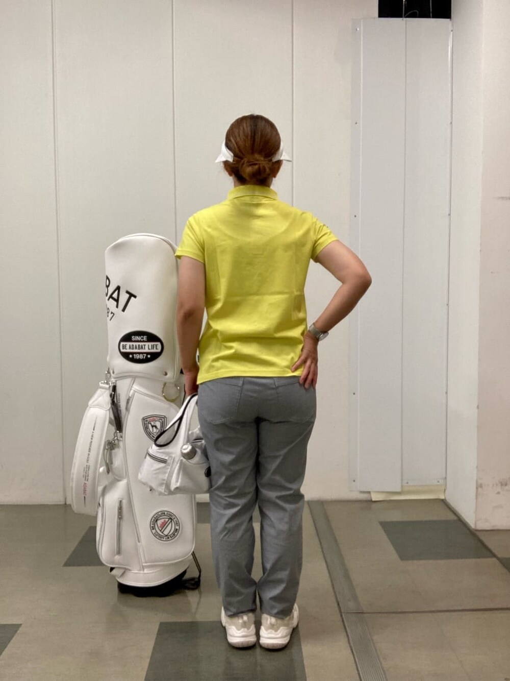 ホワイト系のその他パンツ、イエロー系のポロシャツ、ホワイト系のサンバイザーを着用したレディースの夏コーディネートの3枚目の写真