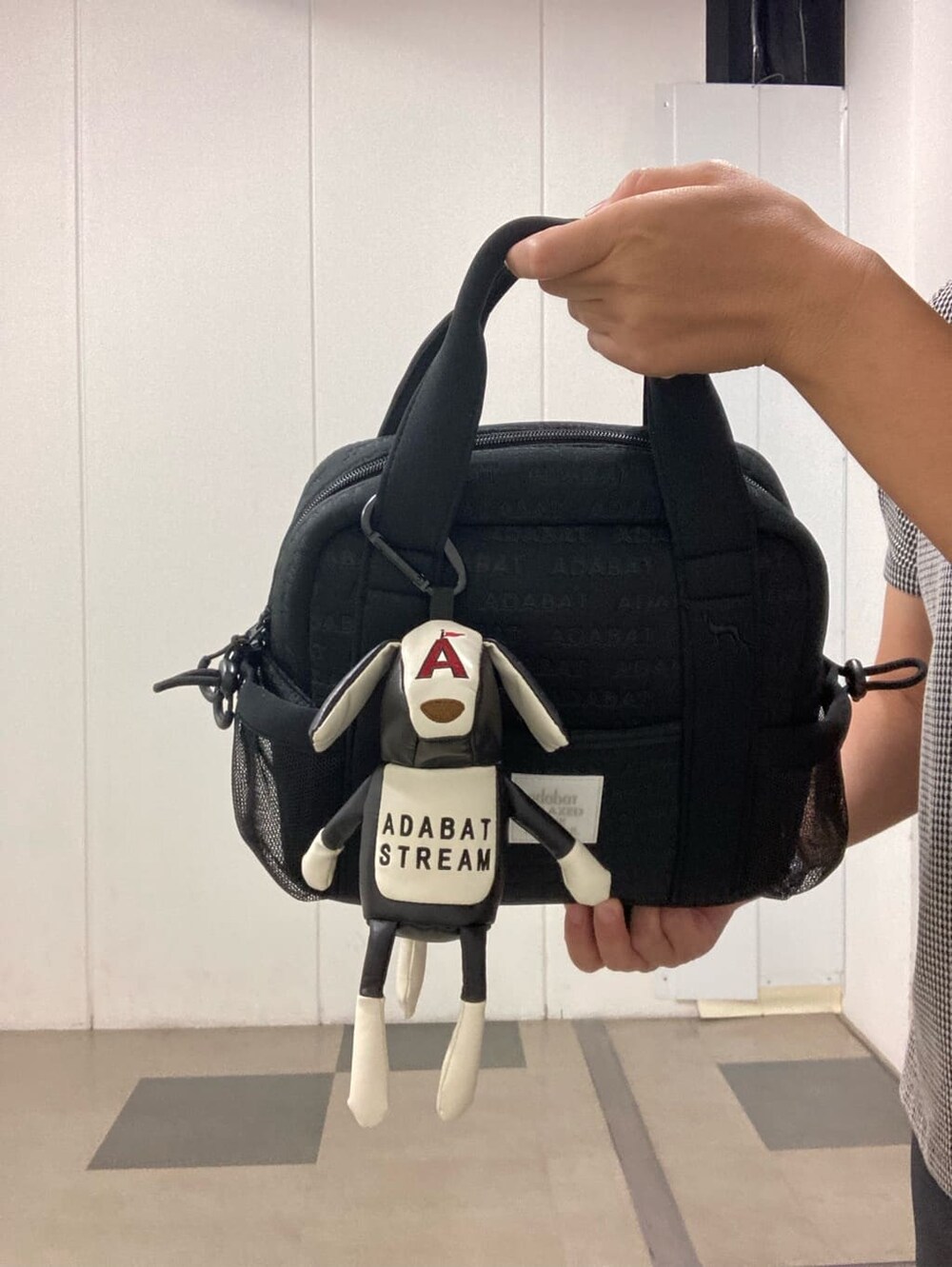 ブラック系のポロシャツ、ブラック系のその他パンツ、ブラック系のハンドバッグを着用したレディースの夏コーディネートの6枚目の写真