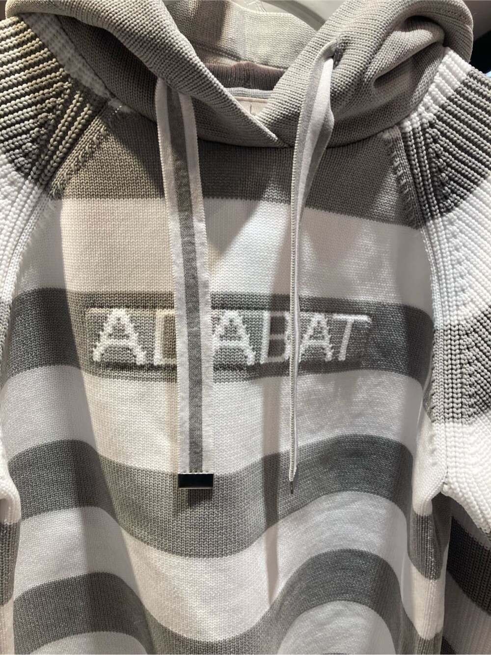 グレー系のニット/セーター、ホワイト系のその他パンツ、グレー系のトートバッグを着用したレディースの秋コーディネートの5枚目の写真