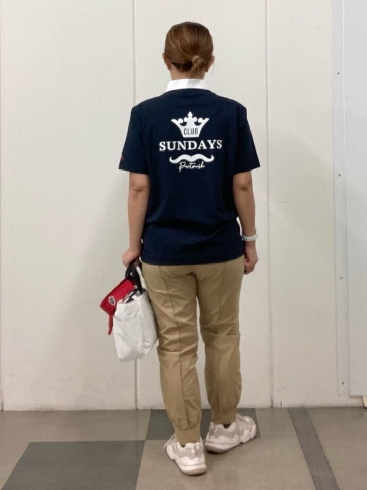 ブルー系のポロシャツ、ベージュ系のその他パンツ、ホワイト系のハンドバッグを着用したレディースの夏コーディネートの3枚目の写真